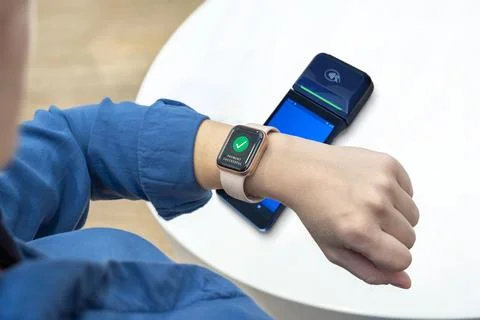 Smart watch completing payment on a POS terminal, worn by a woman Stock Photos