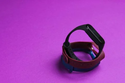Smart watch with interchangeable bracelets on purple background. Fitness trac Stockfoto's