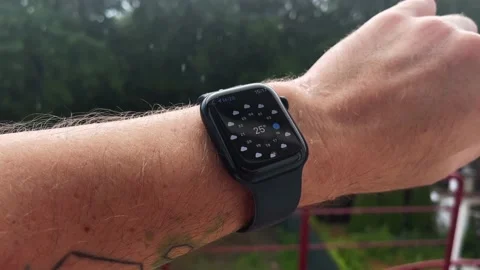 Smart watch on a man's hand, it's raining, shows the weather Stock Footage 200930154