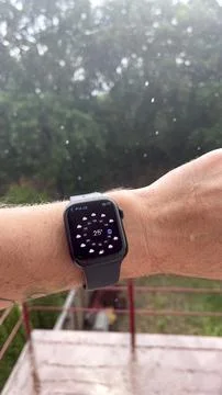 Smart watch on a man's hand, it's raining, shows the weather. Stock Photos