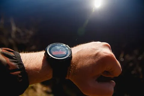 Smart Watch with temperature graph on the screen against sunrise lake background Stock Photos