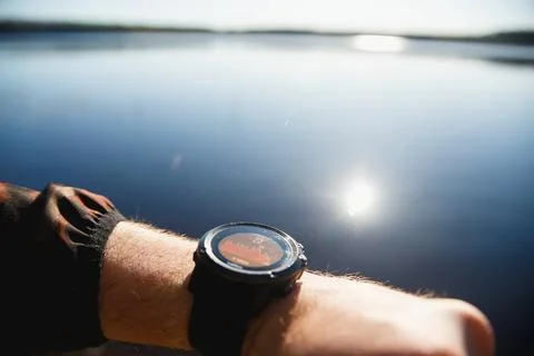Smart Watch with temperature graph on the screen against sunrise lake background Stock Photos