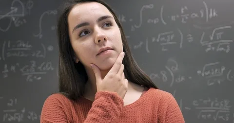 Smart woman thinking and solving problems standing in front of a chalkboard Stock Footage 107148141