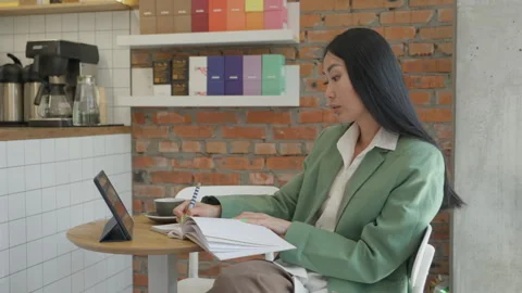 Smart Woman Writing Notes While Talking On Video Call In Modern Coffee Shop Video stock 318986836