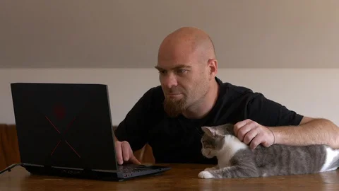 Smart working, covid 19 - young man finish working at computer caressing his cat Vídeo Stock 128184821