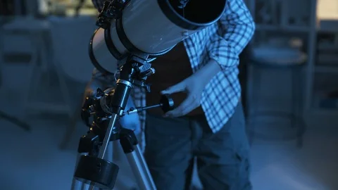 Smart young boy looking through a telescope at night Stock Footage 128500145