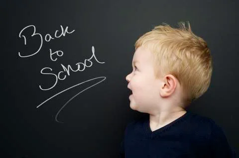 Smart young boy stood infront of a blackboard Stock Photos