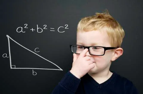 Smart young boy stood infront of a blackboard Stock Photos