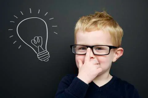 Smart young boy stood infront of a blackboard Фото