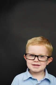 Smart young boy stood infront of a blackboard Stock Photos