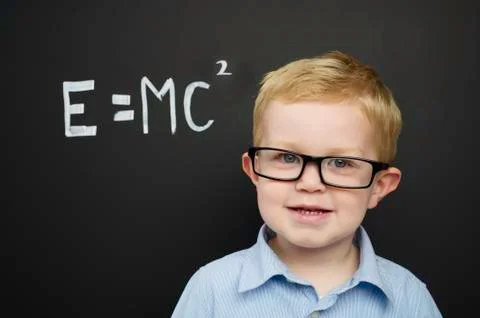 Smart young boy stood infront of a blackboard Stock Photos