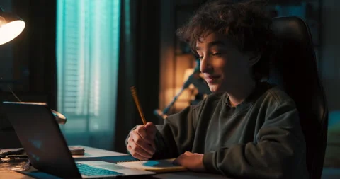 Smart young boy takes notes, draws a project in pencil, does homework, has Stockbeeldmateriaal 200872513