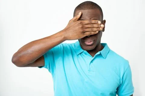 Smart young guy hiding his eyes Stock Photos