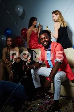 Smart young man with flute of champagne looking at camera Stock Photos