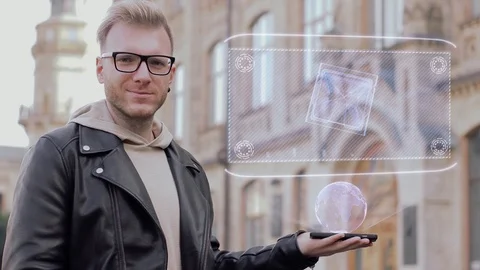 Smart young man with glasses shows a conceptual hologram computer processor Stock Footage 99032068