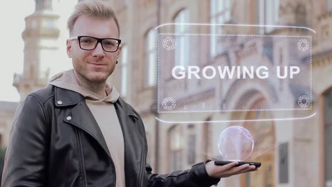 Smart young man with glasses shows a conceptual hologram Growing UP Stock Footage 99735169