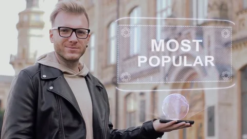Smart young man with glasses shows a conceptual hologram Most popular Stock Footage 99735600