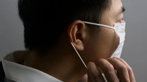Smartly dressed Asian man putting on face mask 動画素材 129844472