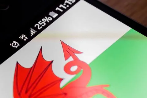 Smartphone 5G network 25 per cent charge and Wales flag Foto stock