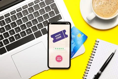 Smartphone with activated promo code, credit card and laptop on yellow backgr Stock Photos