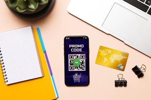 Smartphone with activated promo code, credit card and stationery on beige tab Stock Photos