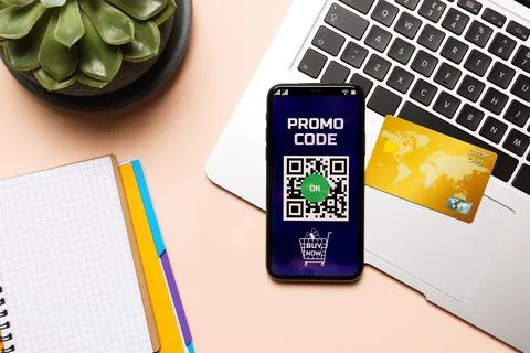 Smartphone with activated promo code, credit card and stationery on beige tab Stock Photos