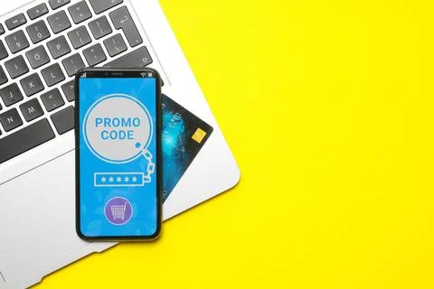 Smartphone with activated promo code, credit card and laptop on yellow back.. Stock Photos