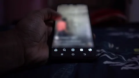 Smartphone addict mindlessly scrolling on smartphone in a dark Stock Footage 252137525