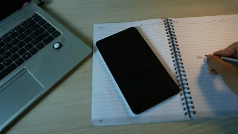 Smartphone and Notebook on Desk with Writing Hand Stock Footage 317736705