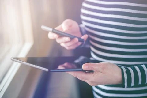 Smartphone and tablet data synchronization, woman syncing files Stock Photos