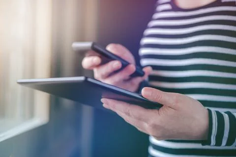 Smartphone and tablet data synchronization, woman syncing files Foto stock
