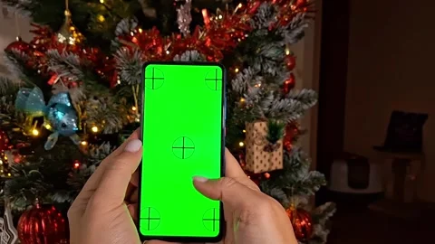 Smartphone app on christmas tree background with festive holiday decorations Video stock 293958406