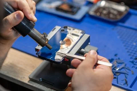 Smartphone Back Glass Replacement technician carefully replaces the rear glas Stock Photos