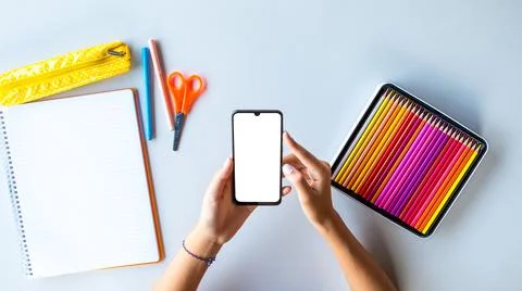 Smartphone back to school empty screen with teenager hands and coloured penci Stock Photos