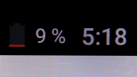 Smartphone battery indicator with a clock indicator. MACRO VIDEO where the Stock Footage 84703594