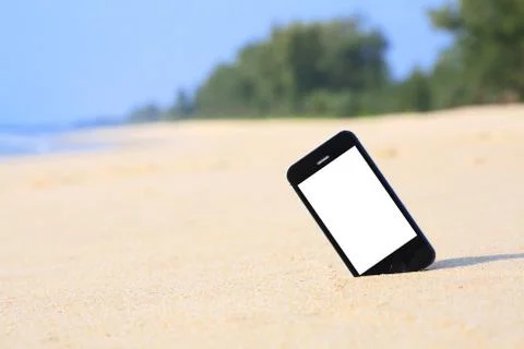 Smartphone on the beach. Stock Photos