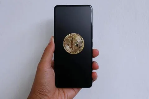 Smartphone with bitcoin display on black screen Stock Photos