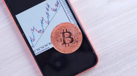 Smartphone with Bitcoin trading chart on the screen. gold Bitcoin Cash coin Stock Photos