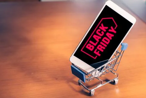 Smartphone with Black Friday on screen inside a small shopping cart, online Stock-Fotos