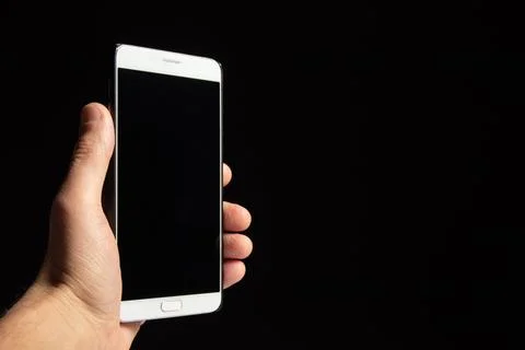 Smartphone with black screen in hand isolated on black background Stock Photos