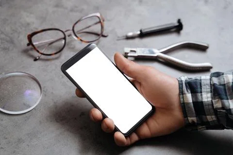 Smartphone with blank display in hand of optician technician Stock Photos