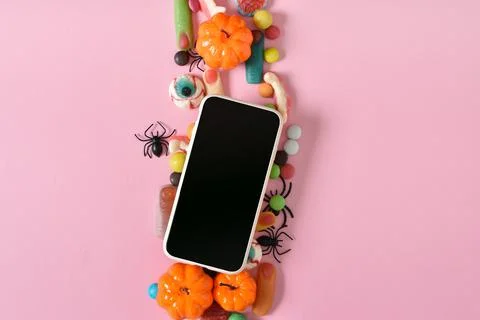 A smartphone with a blank screen on a background of various sweets on a pink  Stock Photos