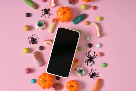 A smartphone with a blank screen on a background of various sweets on a pink  Stock Photos