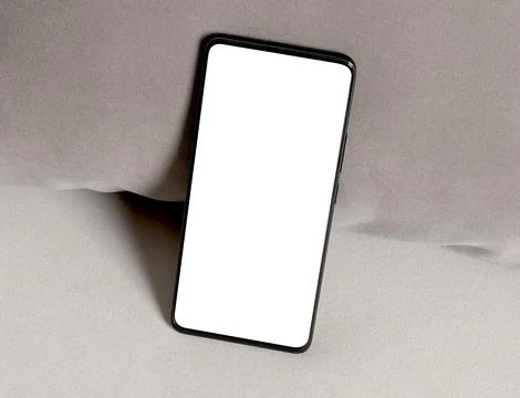 Smartphone with blank screen on soft fabric background. Tilted mobile device Foto stock