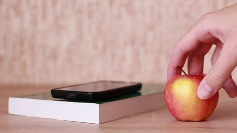 Smartphone on book and apple Stock Footage 83030284