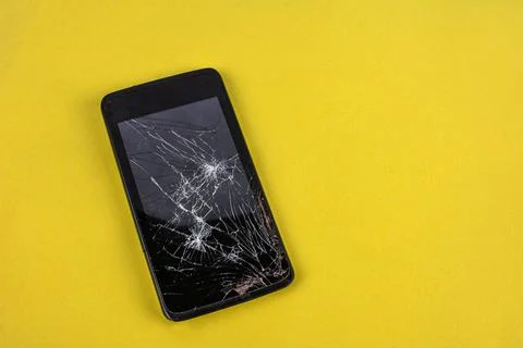 Smartphone with broken screen .Broken mobile phone lying on pavement Stock Photos