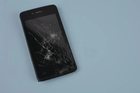 Smartphone with broken screen .Broken mobile phone lying on pavement Stock Photos