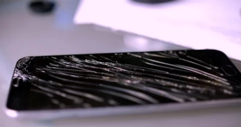 Smartphone with broken screen on table Stock Footage 88730844