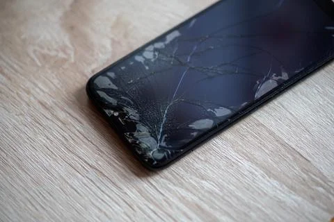 Smartphone with broken touchscreen screen on table desktop Stock Photos