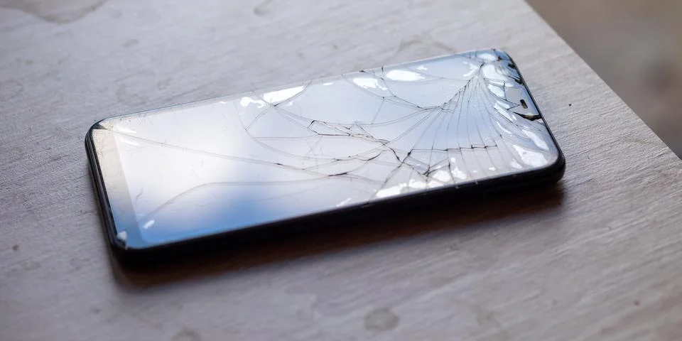 Smartphone with broken touchscreen screen on table desktop Stock Photos